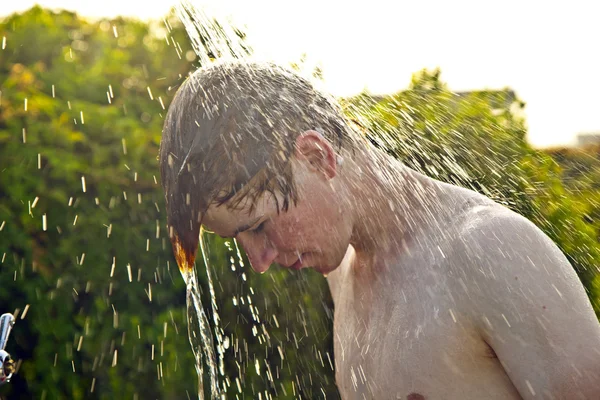 Menino tem um chuveiro na praia — Fotografia de Stock