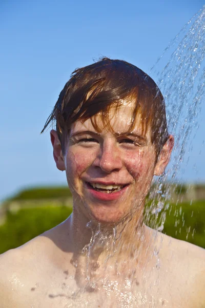 Ragazzo ha una doccia in spiaggia — Foto Stock