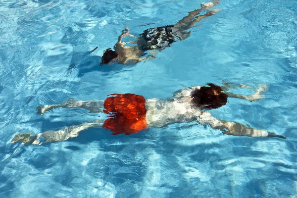 Мальчик плавает в открытом бассейне в солнечный день — стоковое фото