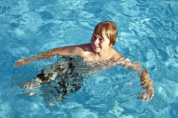 Chico es swinminmg en la piscina al aire libre en un día soleado —  Fotos de Stock