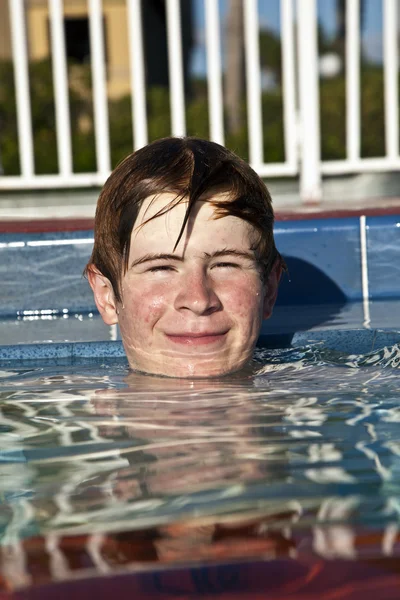 Niño relajante en el borde de la piscina al aire libre —  Fotos de Stock