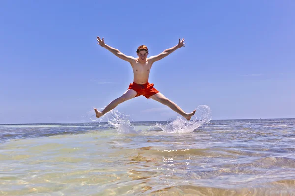 Paradicsom és ricotta torta열 대 해변에서 물 밖으로 점프 하는 어린 소년 — 스톡 사진