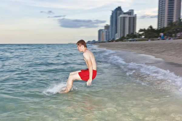 Chłopiec skacze z prędkością do oceanu — Zdjęcie stockowe