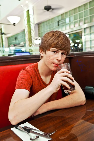 Attraktiver Junge, der nachts in einem Restaurant sitzt — Stockfoto