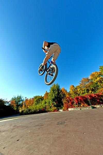 Мальчик летит по воздуху на своем грязном велосипеде — стоковое фото