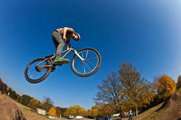 Garçon va dans les airs avec un vélo de saleté — Photo