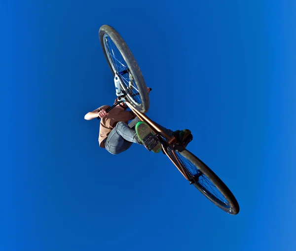 Menino indo no ar com sua bicicleta de sujeira — Fotografia de Stock