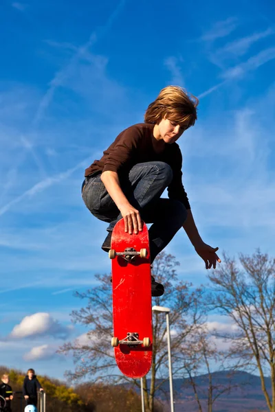 Garçon saute avec son skateboard — Photo