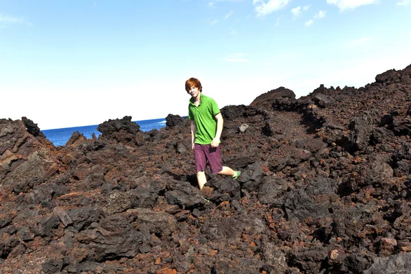 Ragazzo a piedi nella zona vulcanica — Foto Stock