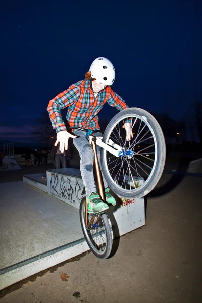 Chico en su dirtbike saltando en el parque de skate por la noche —  Fotos de Stock