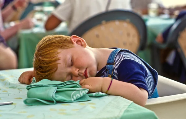 Jongen in slaap vallen op de tafel — Stockfoto