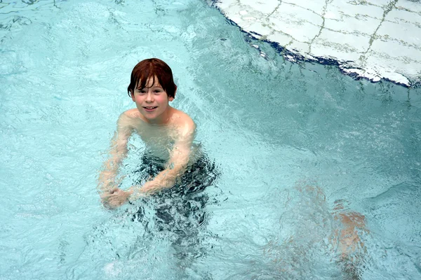 Młody chłopak ma zabawy w publiczny kryty basen — Zdjęcie stockowe