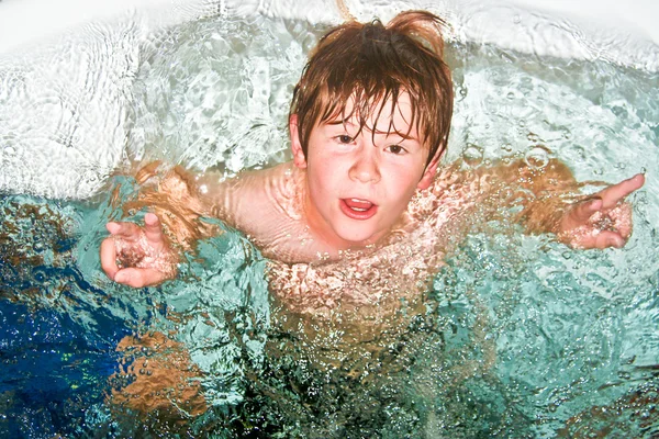 Chłopak pokazuje znak zwycięstwa w basenie — Zdjęcie stockowe