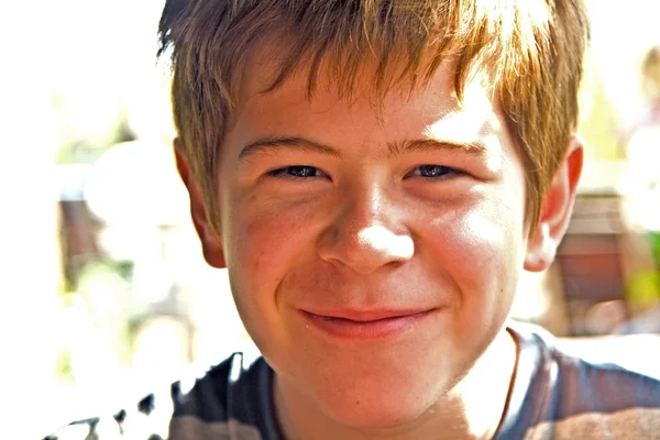 Мальчик с рыжими волосами улыбается и счастлив — стоковое фото