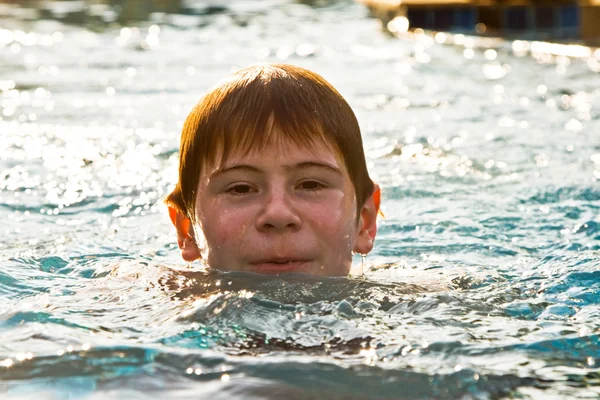 红头发的男孩游泳的游泳池和 enyoing 新鲜 — 图库照片