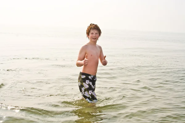 Fiatal fiú a tenger hideg vízzel, de rendben, bemutatás, thumps — Stock Fotó