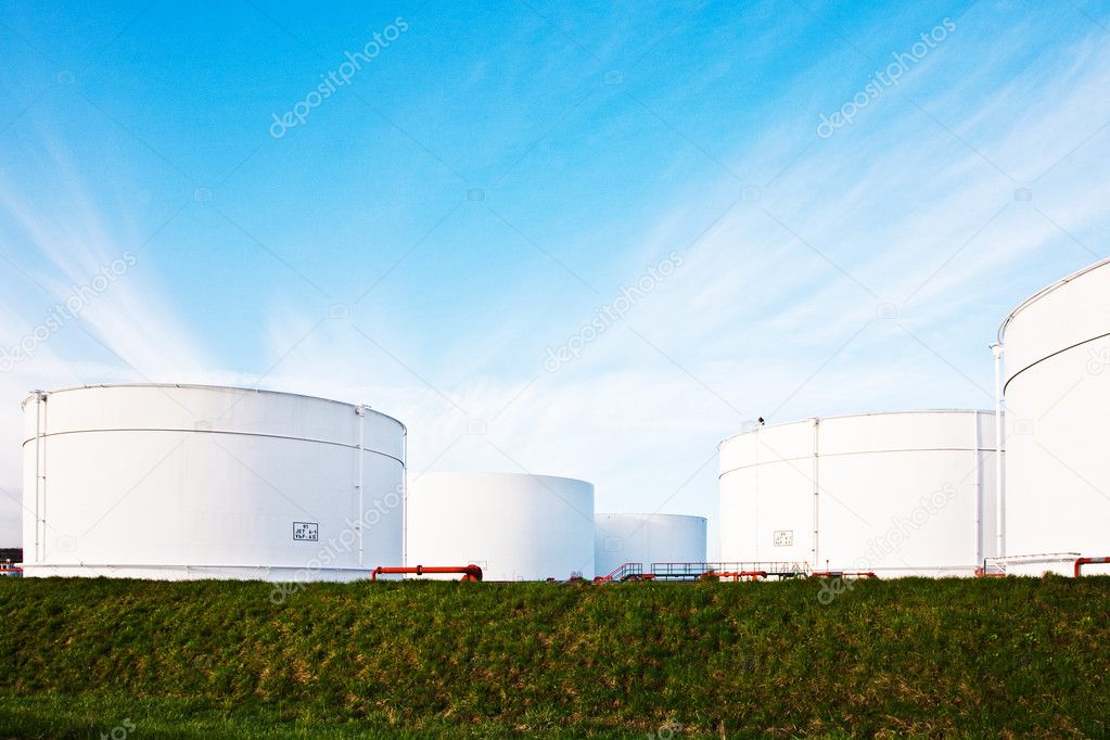 White tanks for petrol and oil in tank farm with blue sky