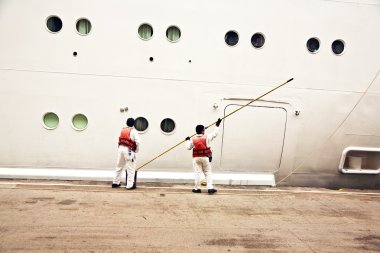 Workers are painting the ships body clipart