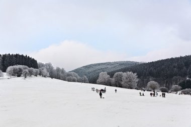 Children are skating at a toboggan run in winter on snow clipart