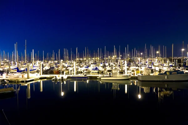 Segelbåtar i vindstilla hamnen vid piren på natten — Stockfoto