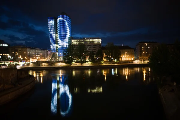 Glass front of office tower by night — Stock Photo, Image