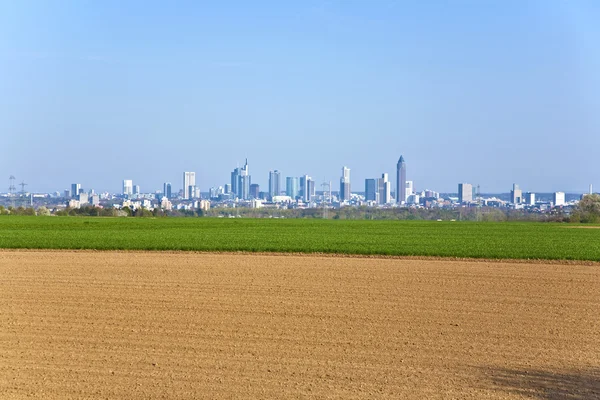 Freshly plowed field with cityscape of Frankfurt at the horizon — Stock Photo, Image