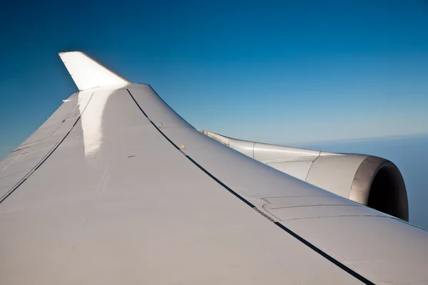 푸른 하늘에 떠 있는 비행기의 날개 — 스톡 사진