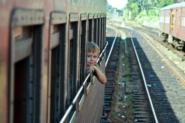 Boy looking out of the railway in scenic landscape in Sri Lanka clipart