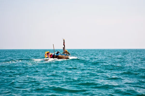 मछुआरे अपनी छोटी लकड़ी की नाव को खुले समुद्र में ले जाते हैं — स्टॉक फ़ोटो, इमेज