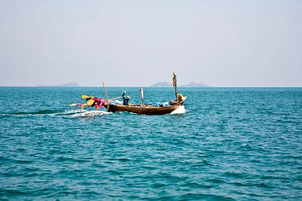 Pescador dirige su pequeño barco de madera hacia el mar abierto — Foto de Stock