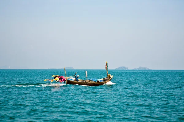 Pescatore dirige la sua piccola barca di legno verso il mare aperto — Foto Stock