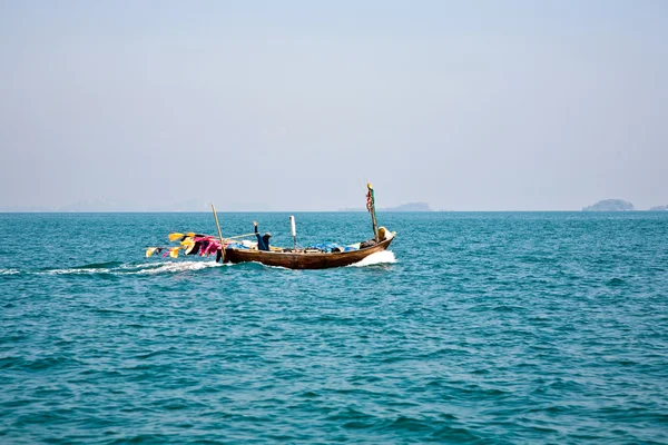 Pescatore dirige la sua piccola barca di legno verso il mare aperto — Foto Stock