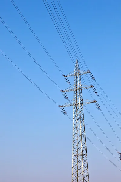 Elektrik kule mavi gökyüzü karşı güç hatları ile — Stok fotoğraf