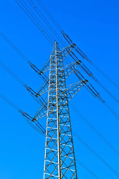 Elektrik kule mavi gökyüzü karşı güç hatları ile — Stok fotoğraf