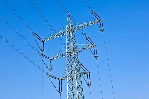 Elektriciteit toren met elektrische leidingen tegen een blauwe hemel — Stockfoto