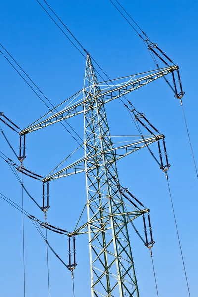 Torre de electricidad con líneas eléctricas contra un cielo azul —  Fotos de Stock
