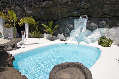 Swimming pool in natural volcanic rock area clipart