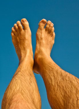 Leg and feet of a man with blue sky clipart