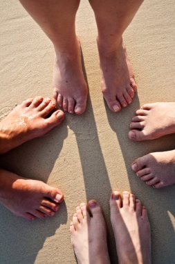ayakları bir ailenin ince kum kıyıya vurmuş, gruplandırılmış bir c