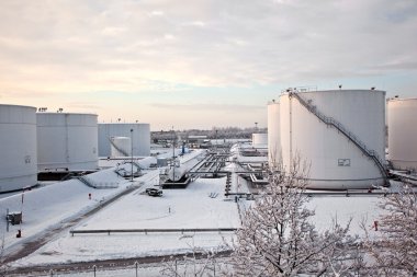 White tanks in tank farm with snow in winter clipart