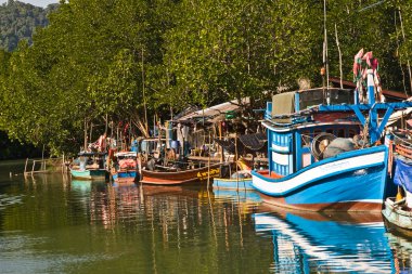 Huts and colorful fisherboats at the mangrove everglades in a s clipart