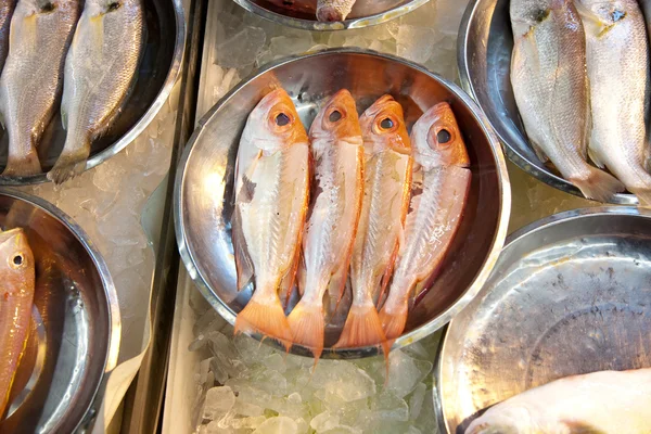Целые свежие рыбы предлагаются на рыбном рынке в Азии — стоковое фото