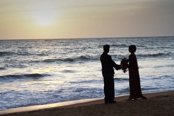 Manželé stojí na pláži šťastný v západu slunce — Stock fotografie