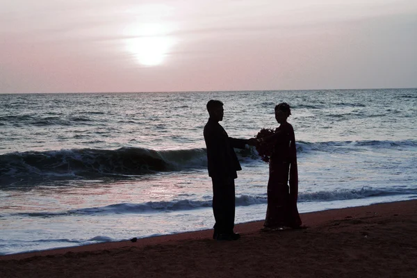 Одружена пара стоїть щасливою на пляжі під час заходу сонця — стокове фото