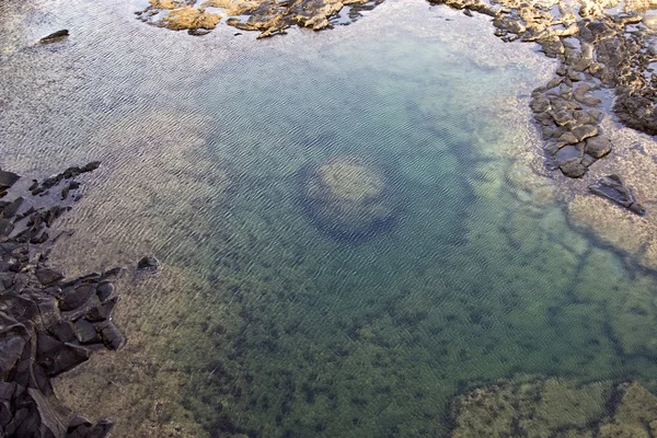 Schöne Steinstruktur an der Küste, die ein natürliches Poo verleiht — Stockfoto
