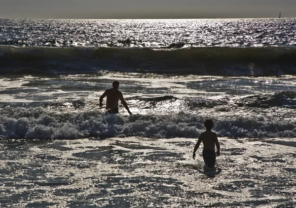 Banho ao pôr-do-sol em ondas na praia — Fotografia de Stock