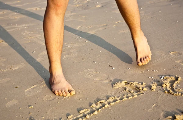 Πόδια ενός αγοριού είναι ζωγραφική αριθμών στην λεπτή άμμο από την — Φωτογραφία Αρχείου