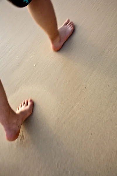 Fötter av en pojke är målning siffror i den fina sanden på beauti — Stockfoto