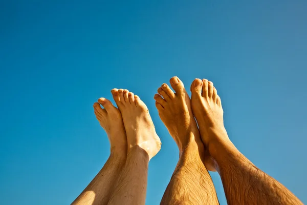 Leg and feet of man and child with blue sky — Stock Photo, Image