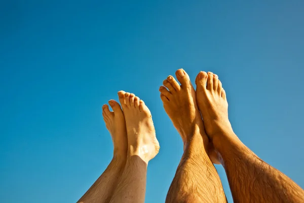 Perna e pés de homem e criança com céu azul — Fotografia de Stock